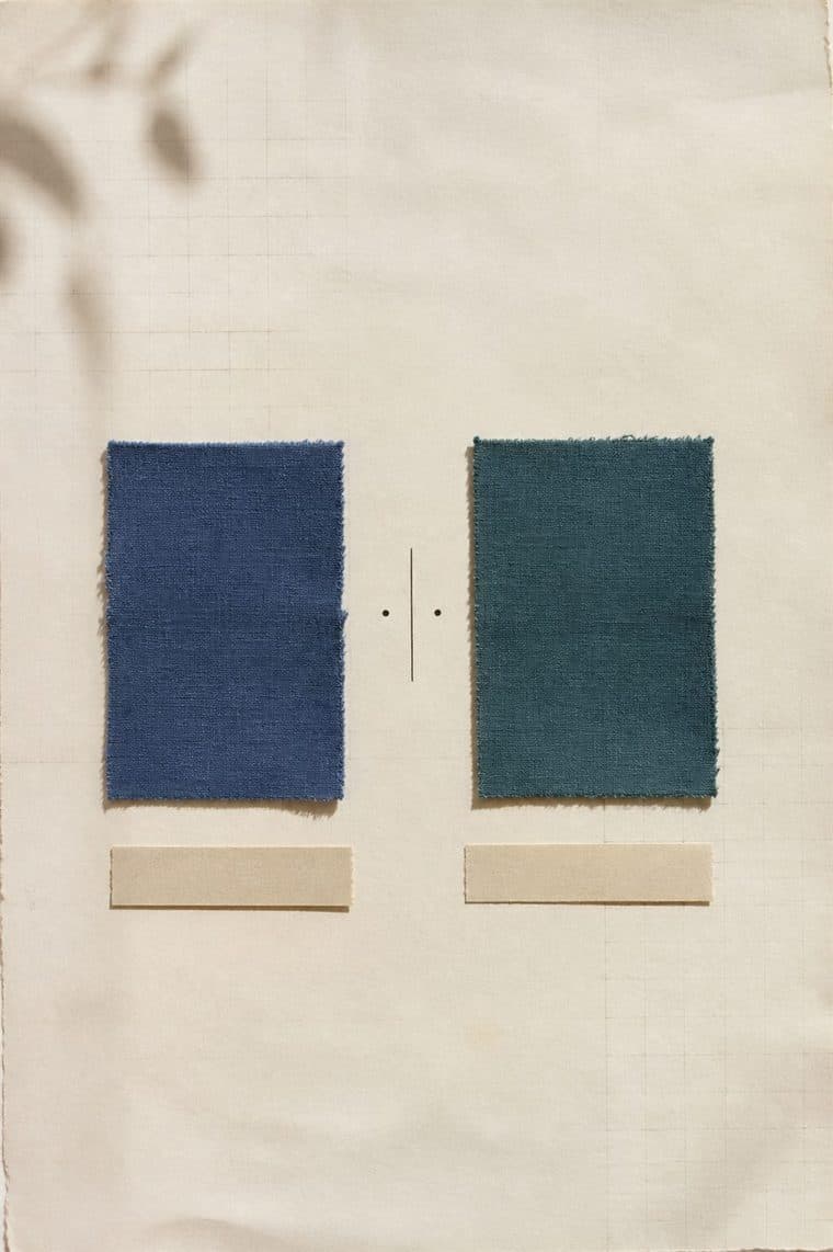 Two fabric swatches of equal size, blue and green, on either side of a vertical axis with two dots